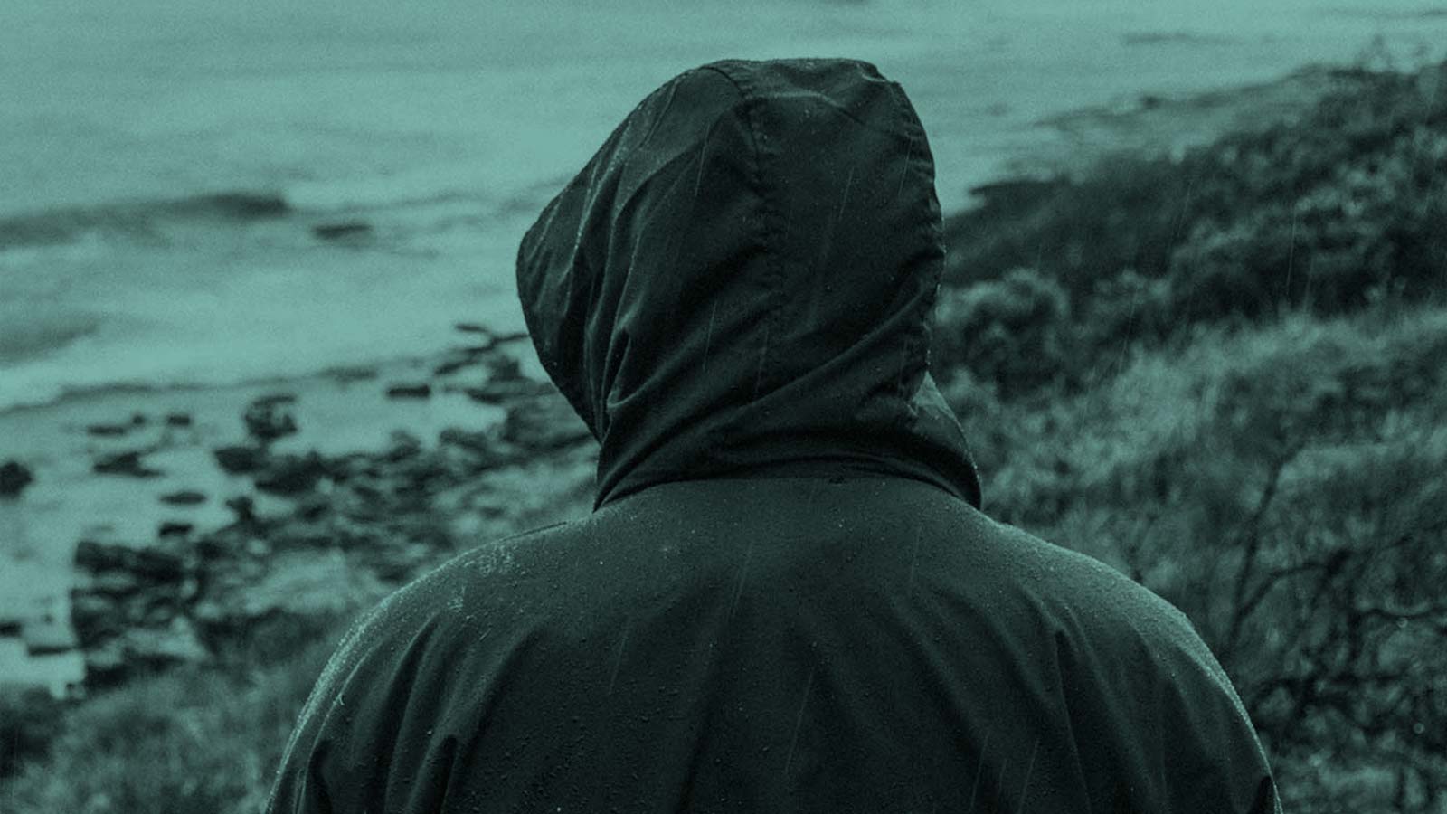 Rainy Day on the beach. Rain poncho is a real shelter from storms and rain.